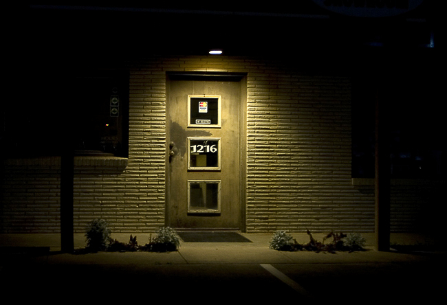 image of business front door at night with spotlight shining down over entrance